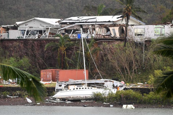 A boat is seen smashed against a bank at Shute Harbour