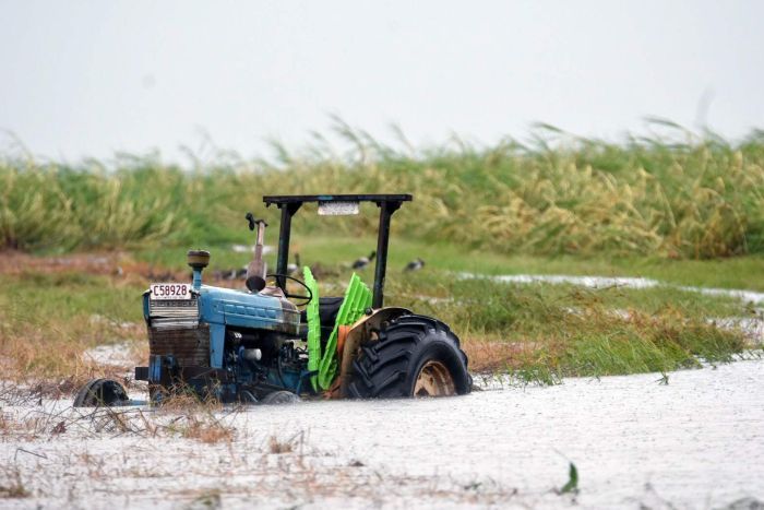 A tractor is seen inundated with water on a property south of Bowen.