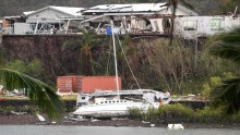 A boat is seen smashed against a bank at Shute Harbour