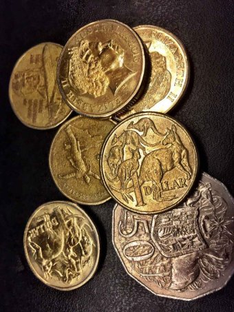 A selection of Australian coins against a black background