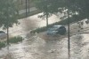 Cars drive through flood waters caused by a burst water main on Constitution Avenue in Canberra.