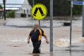 A man walks through the flooded Lismore CBD on Friday morning.