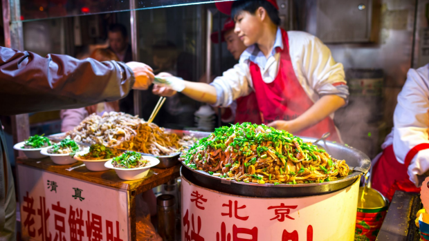 Wangfujing Snack Street at night: Chinese chef selling ancient Beijing soiled pork tripe in Beijing, China.