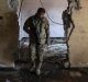 An Iraqi police officer walks in a house that was used as a bomb factory by Islamic State militants in Mosul, Iraq.