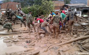 In this handout photo released by the Colombian National Army, soldiers and residents work together in rescue efforts in Mocoa, Colombia, Saturday, April 1, 2017, after an avalanche of water from an overflowing river swept through the city as people slept.