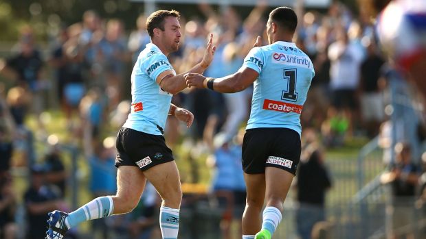 James Maloney (left) of the Sharks celebrates kicking a field goal.