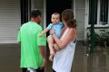 Former Cyclone Debbie caused flooding in Beenleigh. John Eagan, Alishea Walsh and baby Braxton Eagan outside Alishea's ...