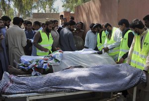 Pakistani volunteers and local residents gather around the bodies of people who were killed in a local shrine, outside the morgue of a hospital in Sarghodha, Pakistan, Sunday, April 2, 2017.