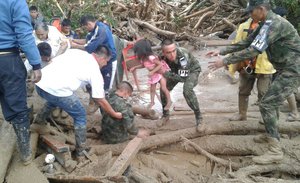 In this handout photo released by the Colombian National Army, soldiers rescue a child in Mocoa, Colombia, Saturday, April 1, 2017, after an avalanche of water from an overflowing river swept through the city as people slept.