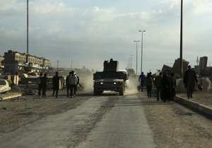 An Iraqi Army armored vehicle patrols while civilians return to their neighborhood recently liberated from Islamic State militants on the eastern side of Mosul, Iraq, Sunday, Jan. 8, 2017.