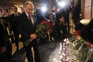 Russian President Vladimir Putin, left, lays flowers at a place near the Tekhnologichesky Institut subway station in St.Petersburg, Russia, Monday, April 3, 2017.