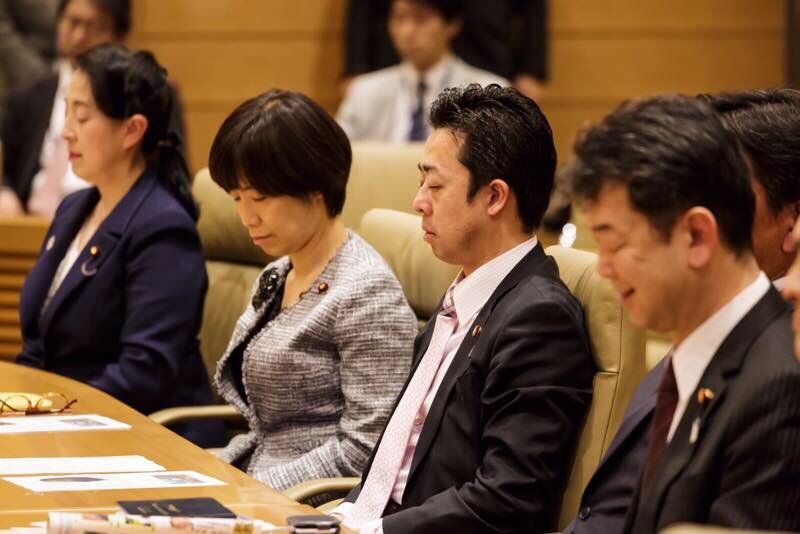 Japanese parliament members meditating.