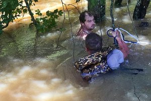 File - Army Sgt. P.J. Freeman works to rescue a citizen whose boat had capsized in fast-moving floodwaters in Livingston Parish near Baton Rouge, La., Aug. 16, 2016.