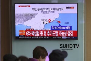 Visitors sit in front of the TV screen showing a news program reporting about North Korea's missile firing, at Seoul Train Station in Seoul, South Korea