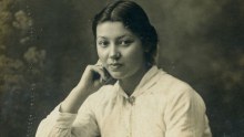 A lady sits for her portrait to be taken in 1915.