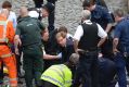 British Tory MP Tobias Ellwood, centre, helps paramedics try to revive the stabbed officer.