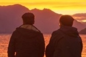 Tourists and locals enjoy a fiery sunset in Queenstown.