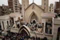 People gather outside the St. George's Church after a deadly suicide bombing, in the Nile Delta town of Tanta, Egypt.