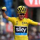 Just champion: Chris Froome lifts after the final stage in Paris