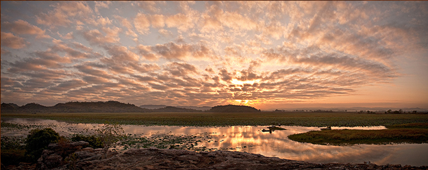 Photograph of the sunset over water and hills. This photograph,  titled Cloud Dreaming, was taken by Flemming Bo Jensen. 