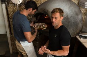 Tim Boyle demonstrates the art of pizza making to Sam Mitchell West Coast Eagles footballer formally of Hawthorn Pam Morris