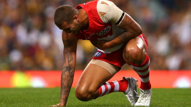 Lance Franklin holds his ribs after a bump by Shannon Hurn.