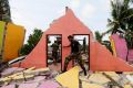 A police officer inspects a damaged house for victims during a rescue mission after a garbage dump collapsed and buried ...