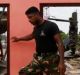 A police officer inspects a damaged house for victims during a rescue mission after a garbage dump collapsed and buried ...