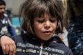 A girl eats food distributed by volunteers in west Mosul.