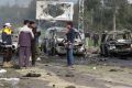 Rebel gunmen at the site of a blast that damaged several buses and vans.