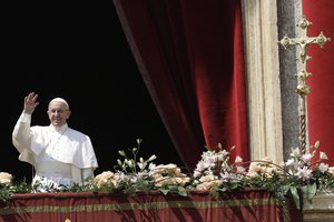 Pope Francis waves prior to delivering his Urbi et Orbi (to the city and to the world) message, from the main balcony of St. Peter's Basilica at the Vatican