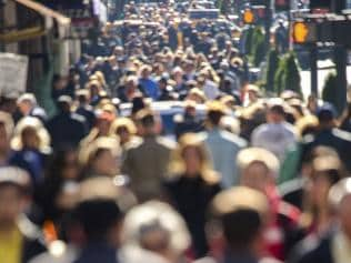 Anonymous crowd of people walking on city street