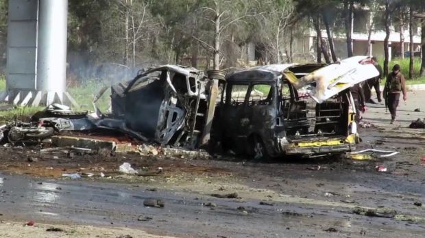 Rebel gunmen at the site of a blast that damaged several buses and vans.