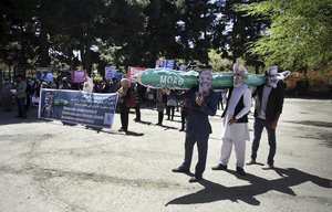 Men from the Solidarity Party of Afghanistan wear masks of President Trump, President Ghani and Dr. Abdullah, carrying a hand made maquette of the "Mother of all bombs" during a demonstration against the U.S. government, in Kabul, Afghanistan, Sunday, April 16, 2017.