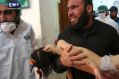 A man carries a child following the suspected chemical attack in the town of Khan Sheikhoun.