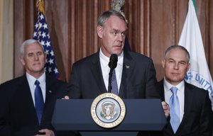 Interior Secretary Ryan Zinke, center, flanked by Vice President Mike Pence, left, and Environmental Protection Agency (EPA), speaks at EPA headquarters in Washington, Tuesday, March 28, 2017