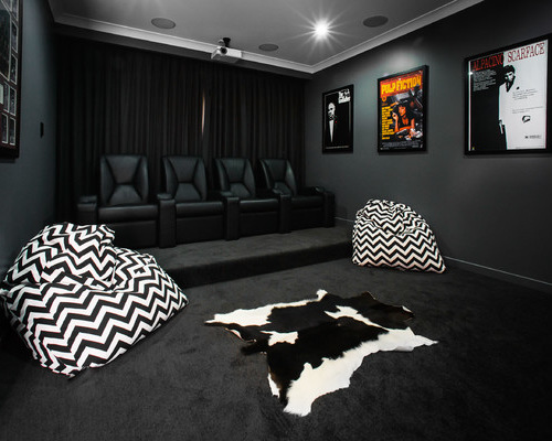 Immagine di un home theatre contemporaneo chiuso con pareti nere, moquette e pavimento nero