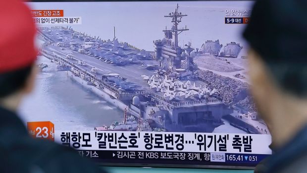 People in Seoul, South Korea, watch a TV news program showing the aircraft carrier USS Carl Vinson on Wednesday.