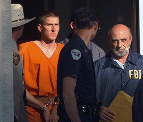 In this April 21, 1995 file photo, Timothy James McVeigh is led out of the Noble County Courthouse by state and federal law enforcement officials in Perry, Okla., after being identified as a suspect in the bombing of the Oklahoma City Federal building.