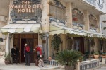 A hotel employee opens the door for a visitor at The Walled Off Hotel, opposite the Israeli security barrier in ...