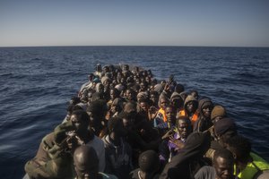 Refugees and migrants from different African countries wait to be assisted by an NGO aboard an overcrowded rubber boat, about 20 miles North of Sabratha, Libya, Saturday, March 4, 2017.