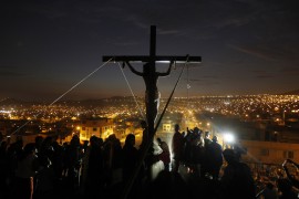 An actor hangs from a cross during the re-enactment of the crucifixion of Jesus Christ during Holy Week at Mi Peru