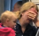 The distraught woman can be seen crying as she clutches her baby.