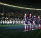 Players stand for the Last Post for the Anzac Day-eve clash in 2015. 