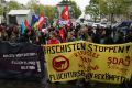  Two police officers were injured and a police car was set ablaze in Cologne as 15,000 people protested at the ...