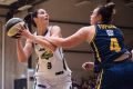 Rangers' Jacinta Kennedy (with the ball) tries to stay clear of the Flames' Tahlia Tupaea in their first playoff.