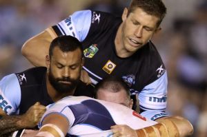 Teamwork: Jarrod Wallace of the Titans is gang-tackled by the Sharks.