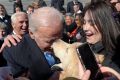 Former Vice President Joe Biden gets a kiss from a dog as he greets the crowd on Capitol Hill in Washington, Wednesday, ...