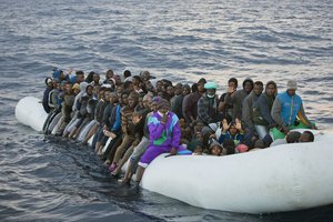 In this Friday, Feb. 3, 2017 file photo, migrants and refugees wait to be helped by members of the Spanish NGO Proactiva Open Arms, as they crowd aboard a rubber boat sailing out of control in the Mediterranean Sea about 21 miles north of Sabratha, Libya.