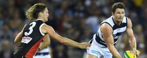 MELBOURNE, AUSTRALIA - APRIL 23: Patrick Dangerfield of the Cats handballs whilst being tackled by Jack Steven and Luke ...